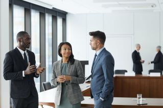 Man in Blue Suit Standing Beside Woman in Gray Blazer